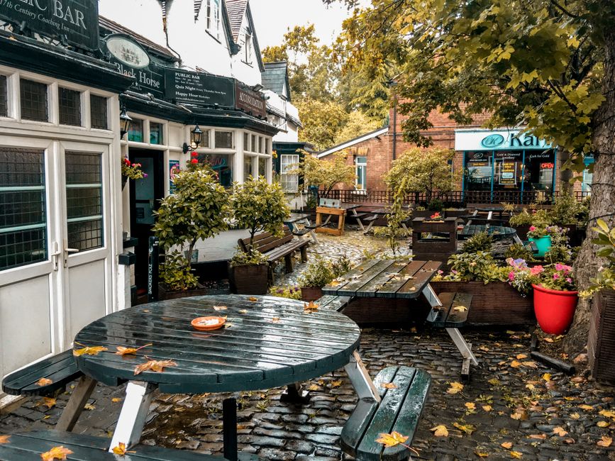 The image depicts the storefront of Northern Flower, a flower shop situated in a brick building with a decorative sign above the window. In front of the shop, there are wooden crates stacked to create